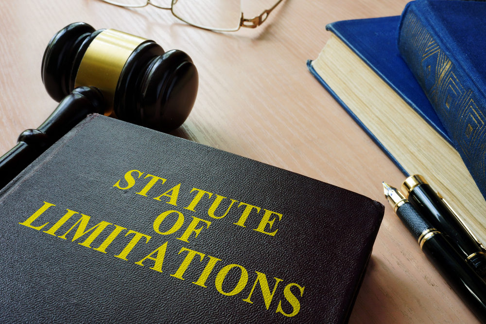 A book title "Statute of Limitations" sits on a table with a gavel