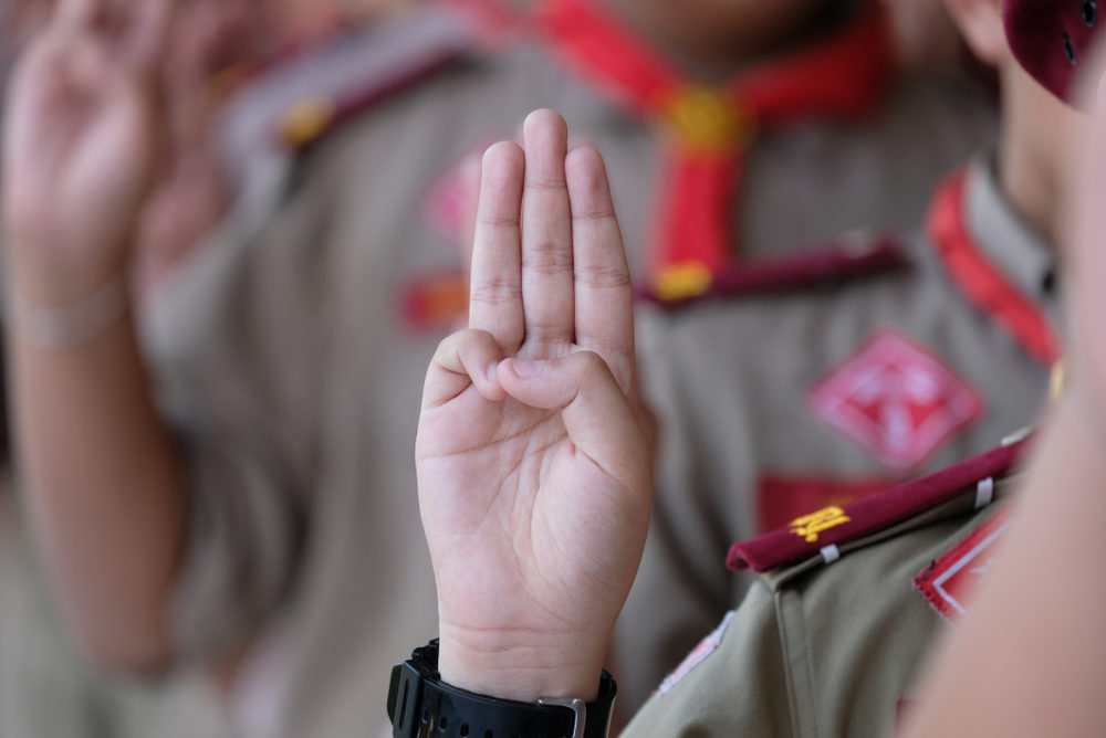 Amid Increasing Lawsuits, Boy Scouts Complain About Legal Ads A boy in a Scout uniform holds up the traditional three-finger salute (the "Scout Sign")