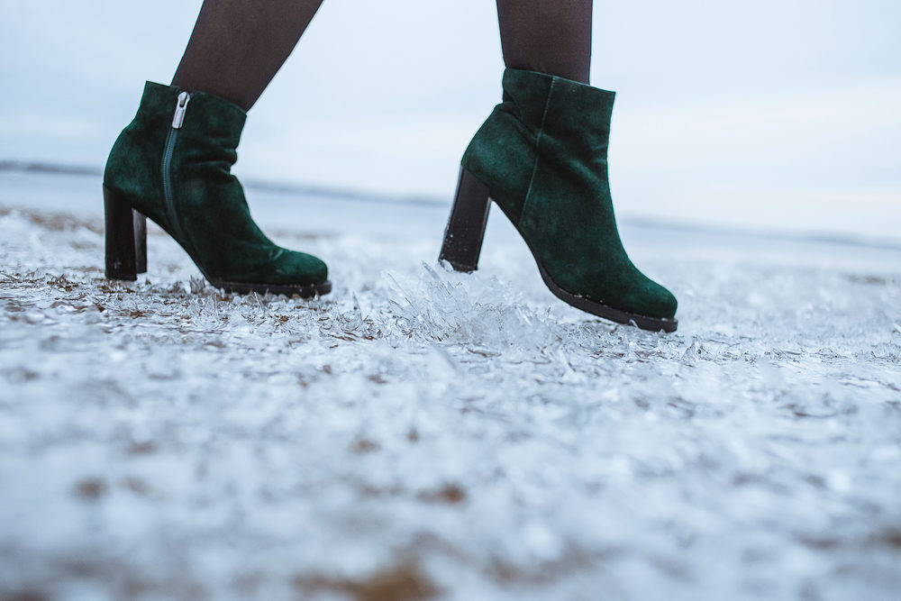 A woman in high heels steps on an icy walkway