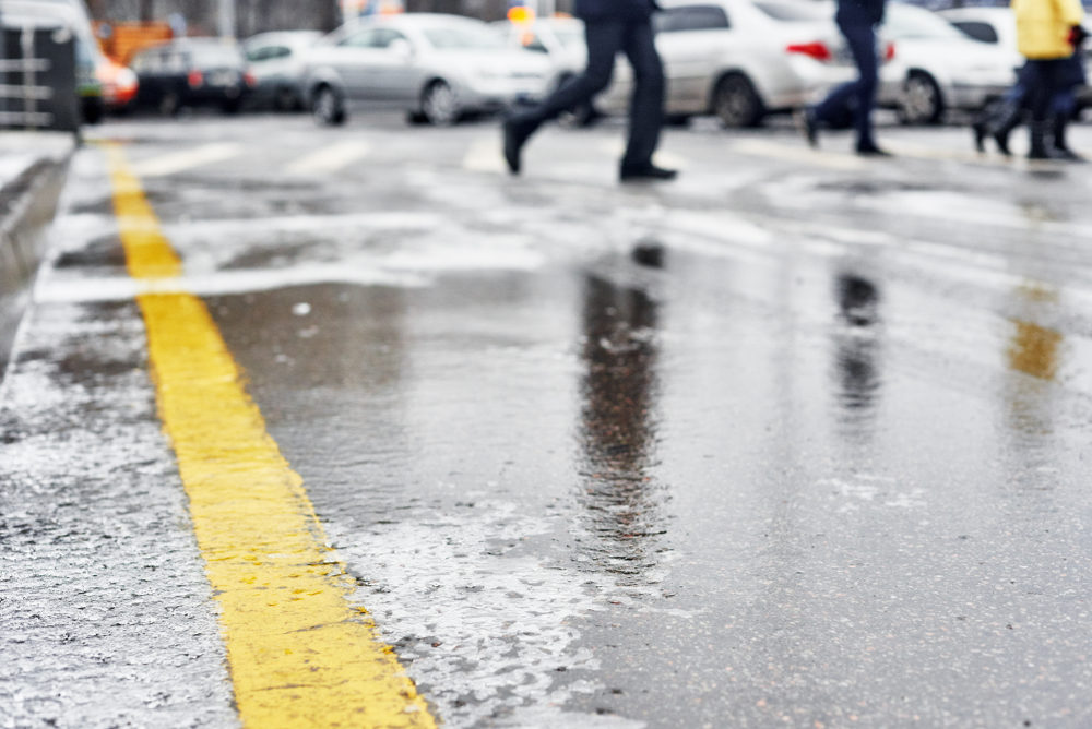 Close-up of an icy surface in a busy parking lot