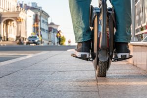 Close-up of the rider's legs on an electric unicycle on a sidewalk