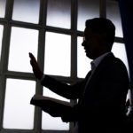 Silhouette of pastor wearing suit with rectangular window frame