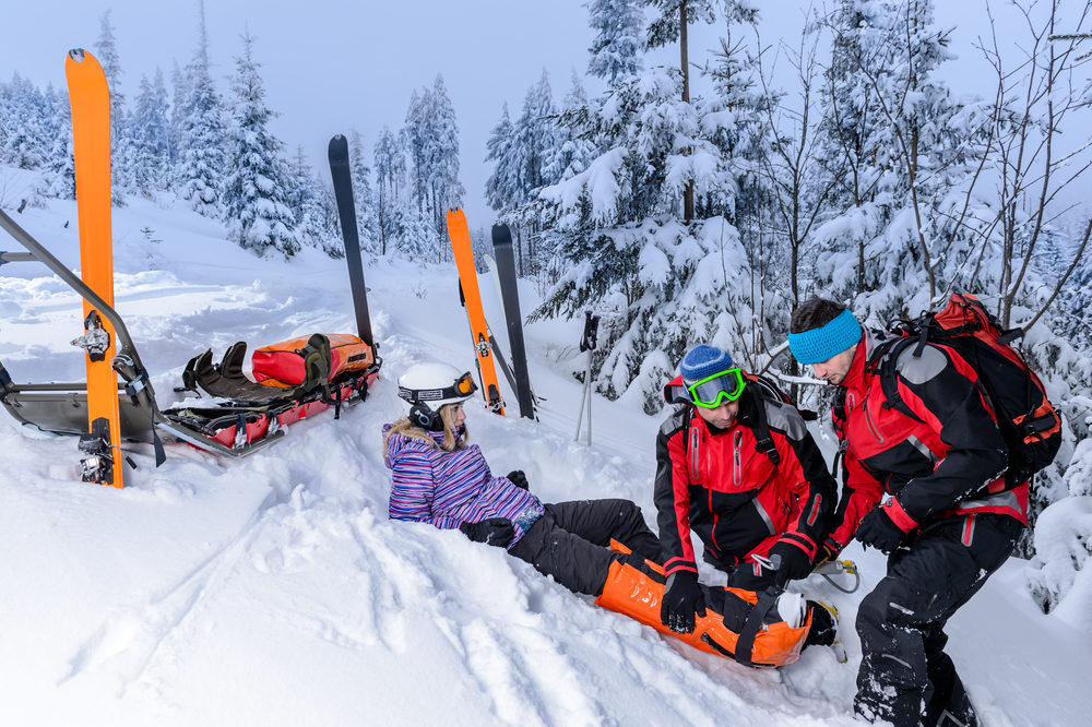 Ski patrol team rescue woman skier with broken leg