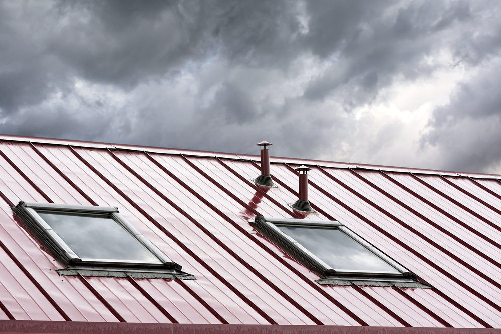 Workers Injured After Falling Through Skylights; Owner Fined for Lying About It red metal roof with skylights against stormy sky