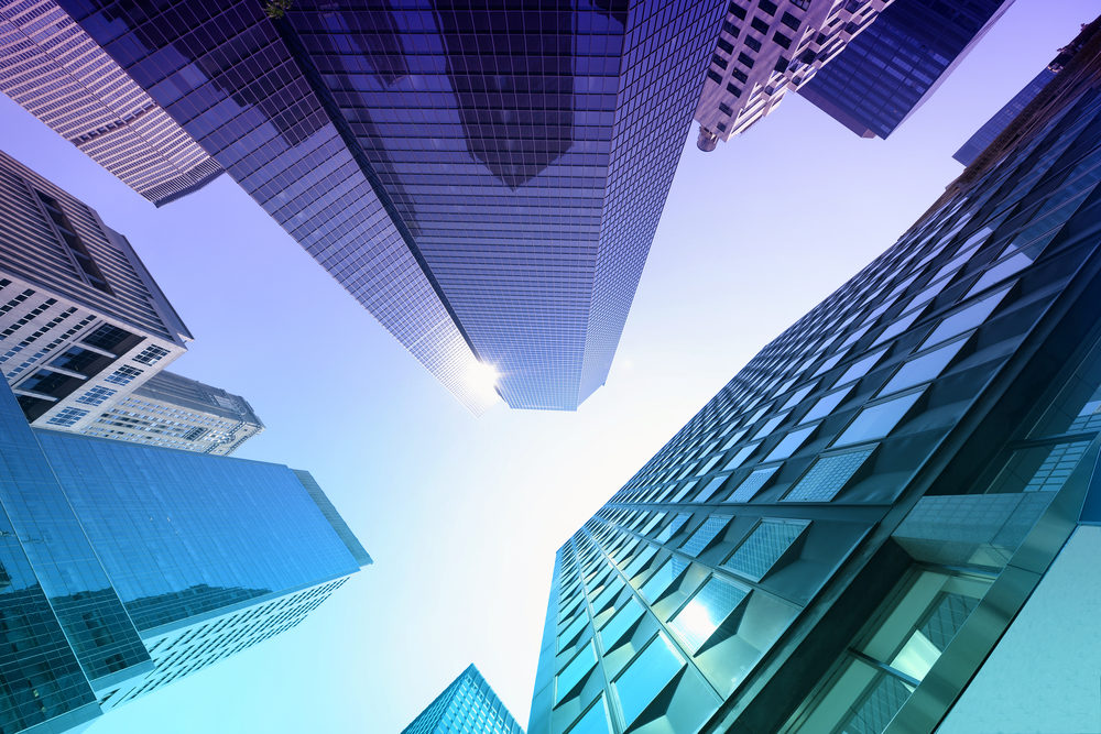 Investment-backed Structures for Employment Settlements A low angle view of towering skyscrapers surrounding the viewer