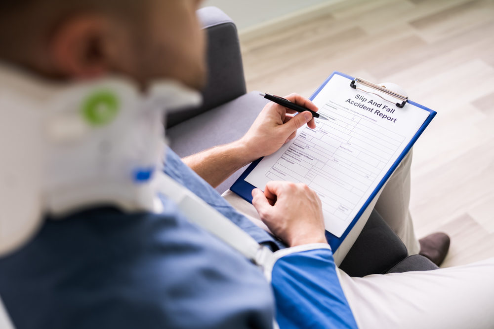 Why It’s So Important to Visit a Doctor After a Slip and Fall A Businessperson With Broken Arm Filling Health Insurance Claim Form