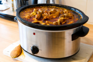 A slow cooker filled with a meaty curry