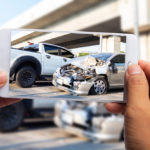 Car insurance agents take pictures of car accident-damaged vehicles with a smartphone as a proof of insurance claim.