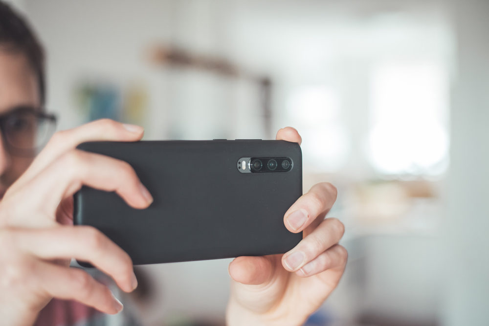 Close up of black smartphone camera, filming and making pictures indoors. 