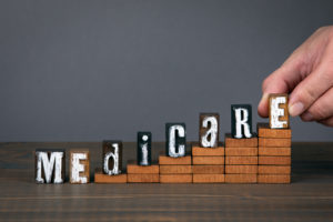 medicare wooden alphabet letters on steps with gray background