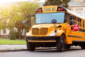stopped yellow school bus outside of school building