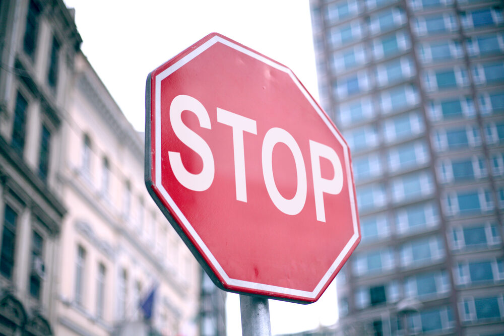 closeup of a stop sign in a city with buildings in the background