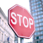 closeup of a stop sign in a city with buildings in the background