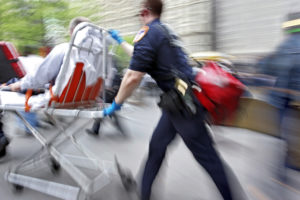 an emt pushing a stretcher with an accident victim to a hospital