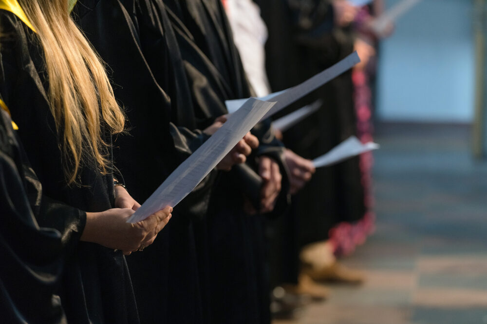 closeup of a student choir with singers holding sheet music