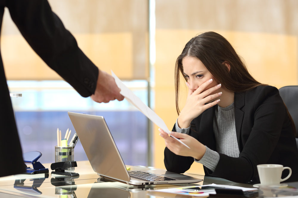 Worried businesswoman receiving a notification from a colleague in her workplace at office