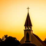 Church steeple against sunset