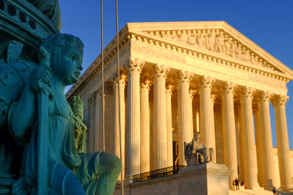 view of Supreme Court Building in Washington DC with a statue in the foreground