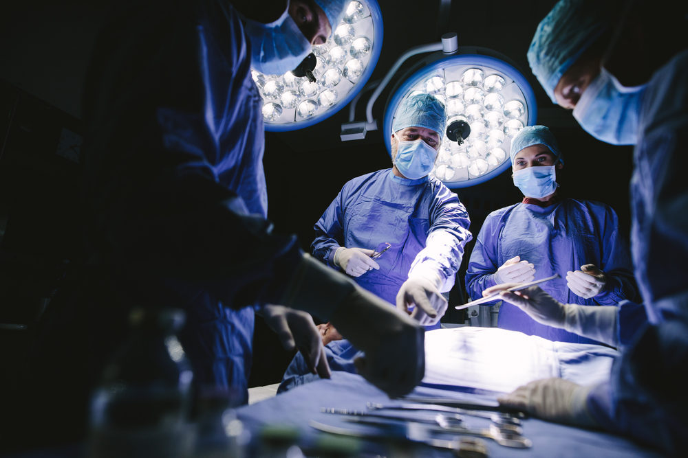 Medical team performing surgery in operation room.