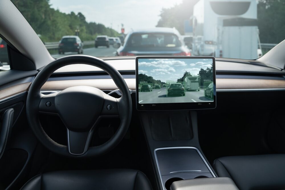 NHTSA Opens Investigation Of Fatal Virginia Truck Crash Involving a Tesla interior view of a tesla on the highway in traffic
