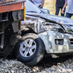 closeup of damaged car after a train collided with it on the railroad tracks
