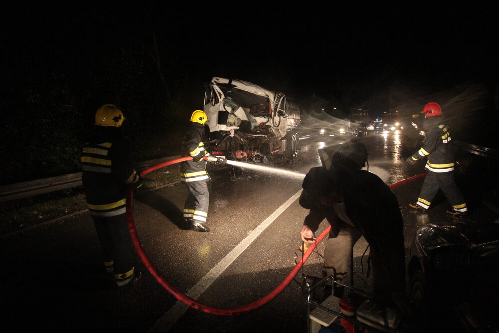 Fatal Single-Vehicle Rollover Crash on I-5 near SR-4 in Stockton firemen spraying off the highway after a truck accident at night