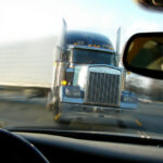 A big rig about to slam into a car head-on, as viewed through the car's windshield