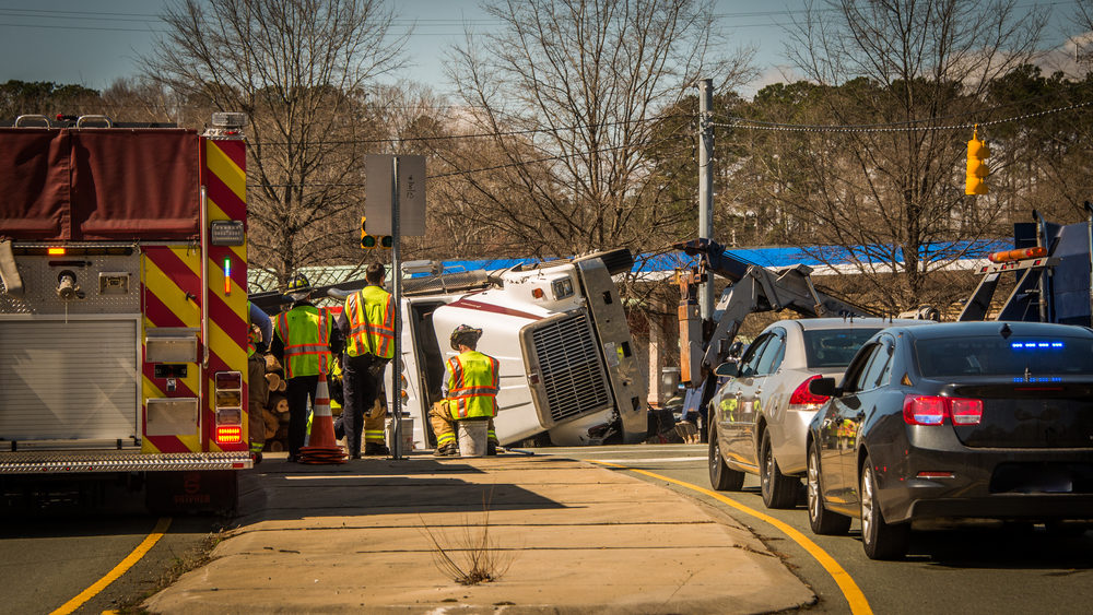 overturned semi truck at intersection with fire truck attending