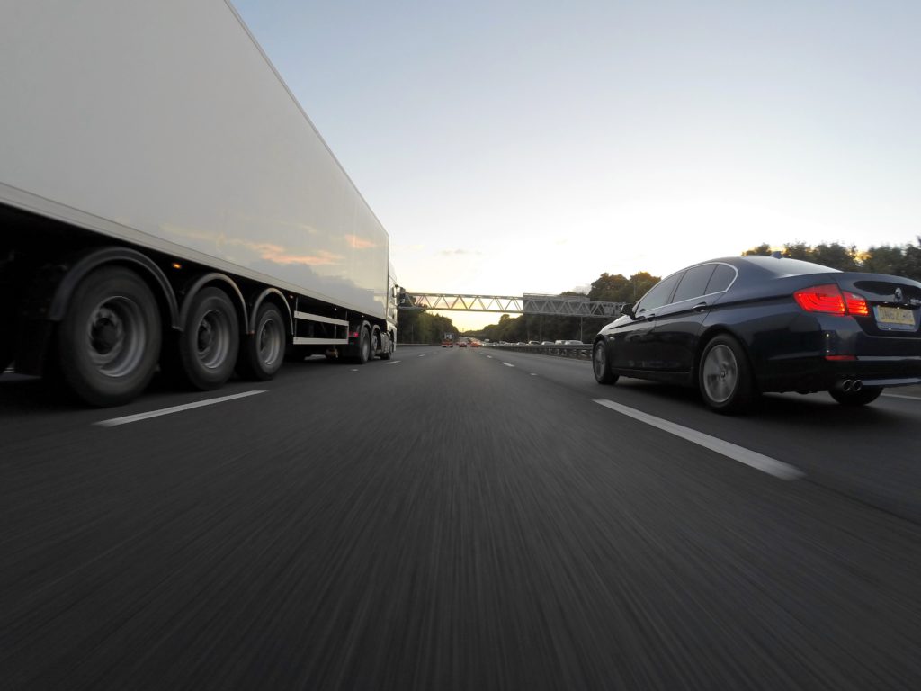 car and tractor trailer on highway