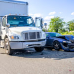 Collision of a semi truck with box trailer and a passenger car on the highway road