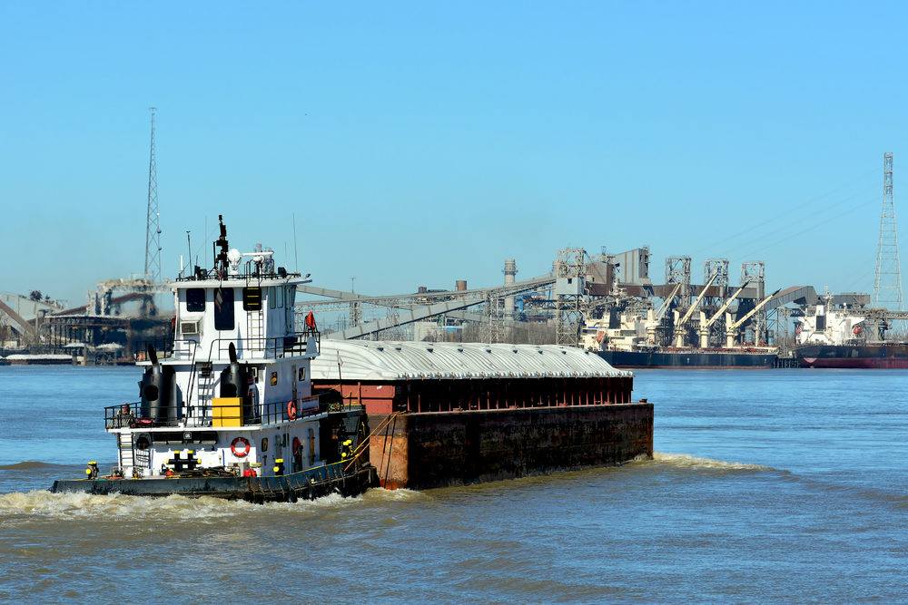 A Tugboat pushes a barge down the Mississippi River at New Orleans.