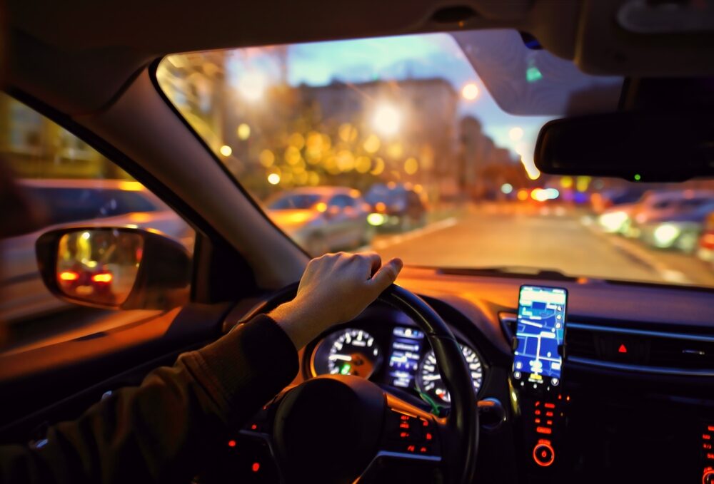 ride sharing driver on a city street at night