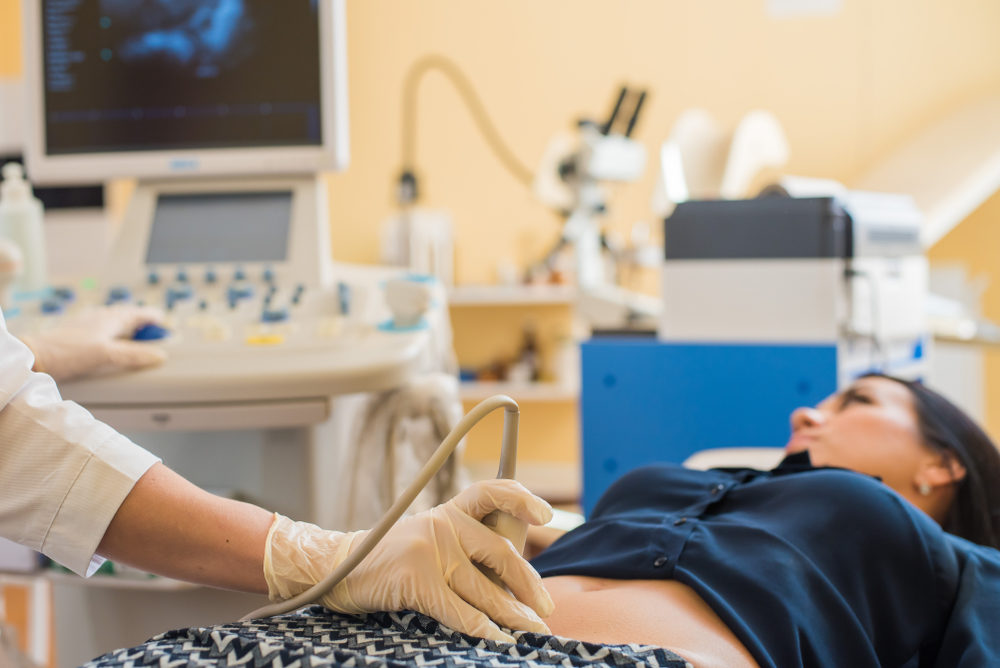 pregnant female visiting women's doctor in the maternity center, doing ultrasound scan