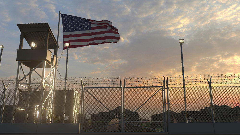 united states flag flying at a military base at dusk