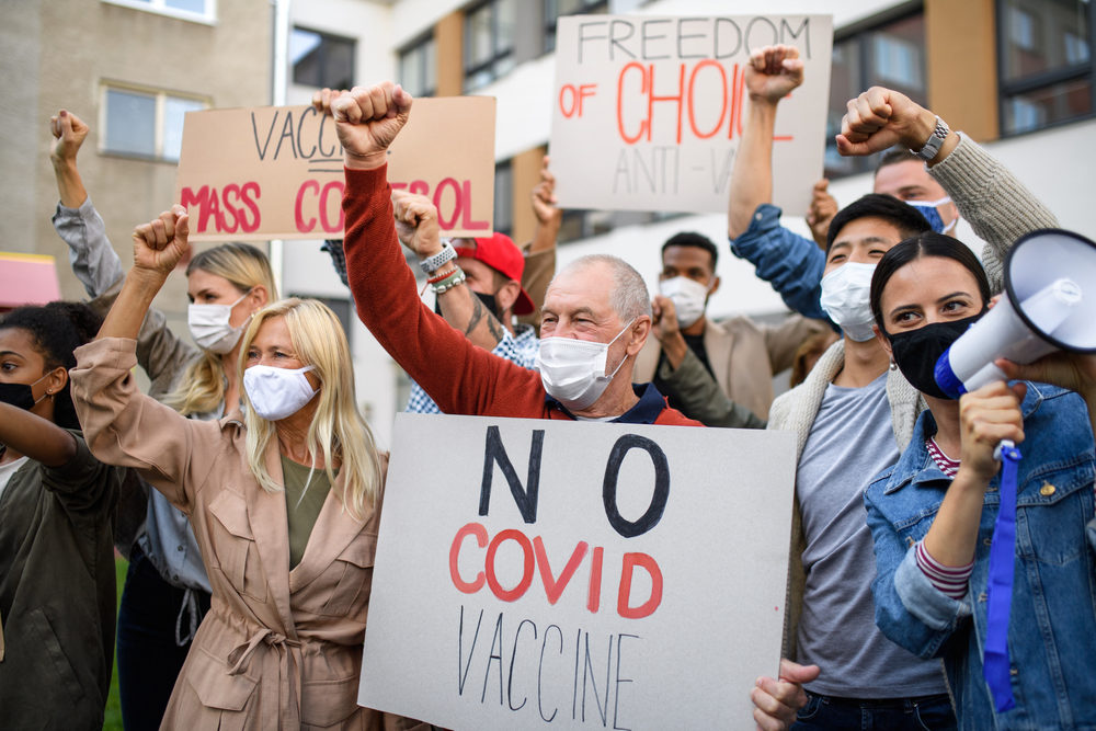 Protestors holding signs  for no covid vaccine