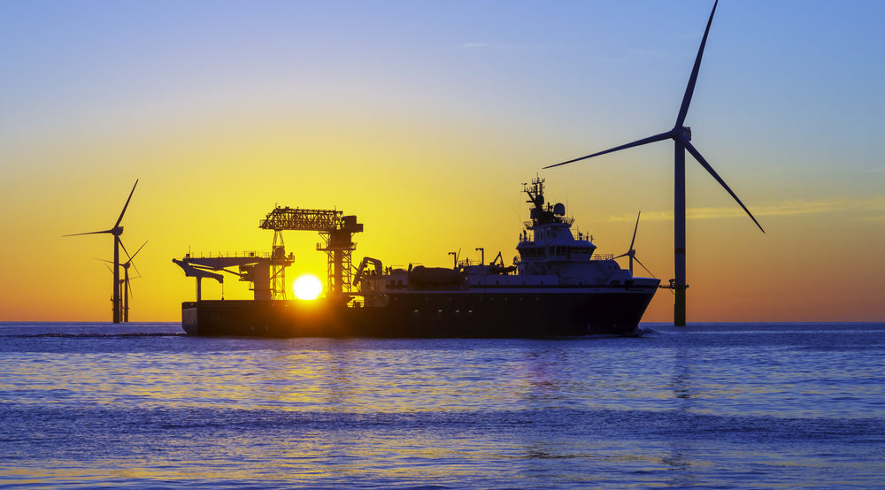 vessel at sunset with wind turbines