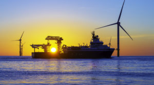 vessel at sunset with wind turbines