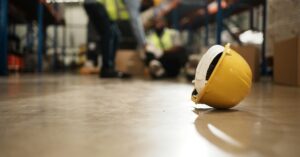 closeup of a hardhat on the floor of a warehouse after workplace injury