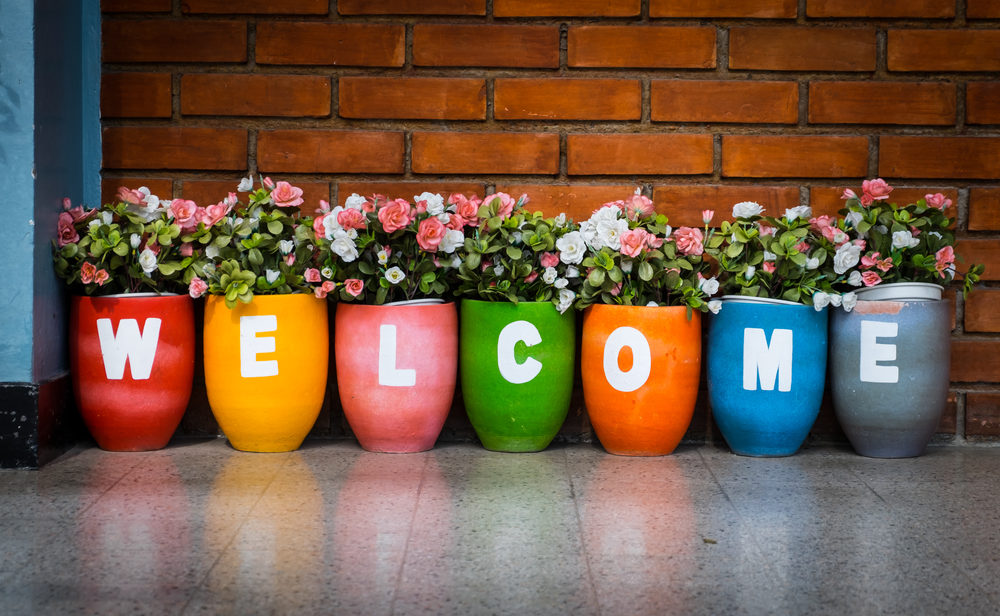 Colorful flowerpots with painted with "WELCOME" letters