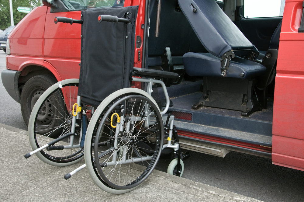 wheelchair access next to a red patient transport van