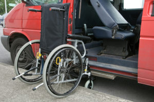 wheelchair access next to a red patient transport van
