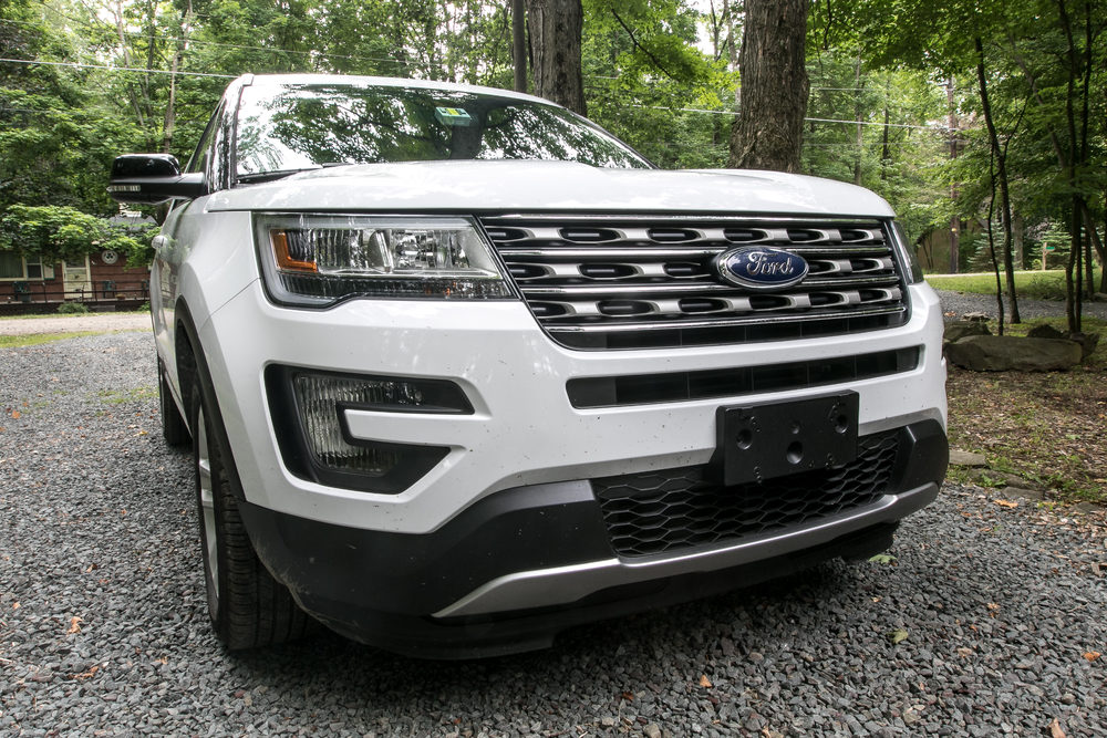 A white Ford Explorer on a gravel driveway