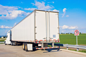 a white semi truck parked in a no parking zone on the side of the road