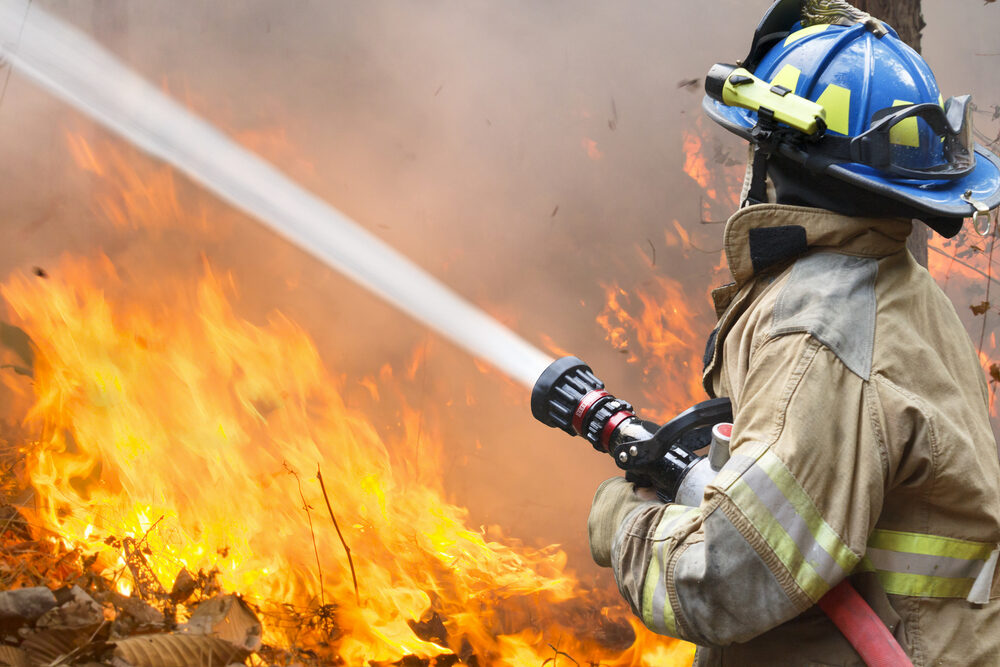 Fire Rips Through Brooklyn Yeshiva Dormitory, Injuring 15 Including Firefighters firefighter battling a wildfire with hose