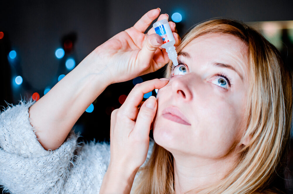 woman dropping eye lubricant to treat dry eye or allergy