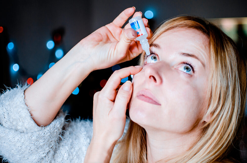 Florida Woman Blames EzriCare for the Infection that Led to the Loss of Her Eye woman dropping eye lubricant to treat dry eye or allergy