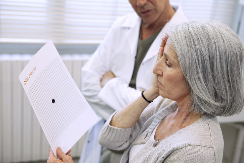 elderly woman getting an eye screening with a male optician observing