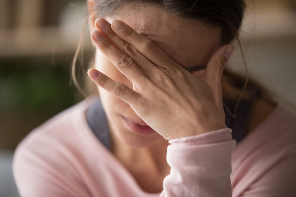 Anguished woman holding her hand to her head