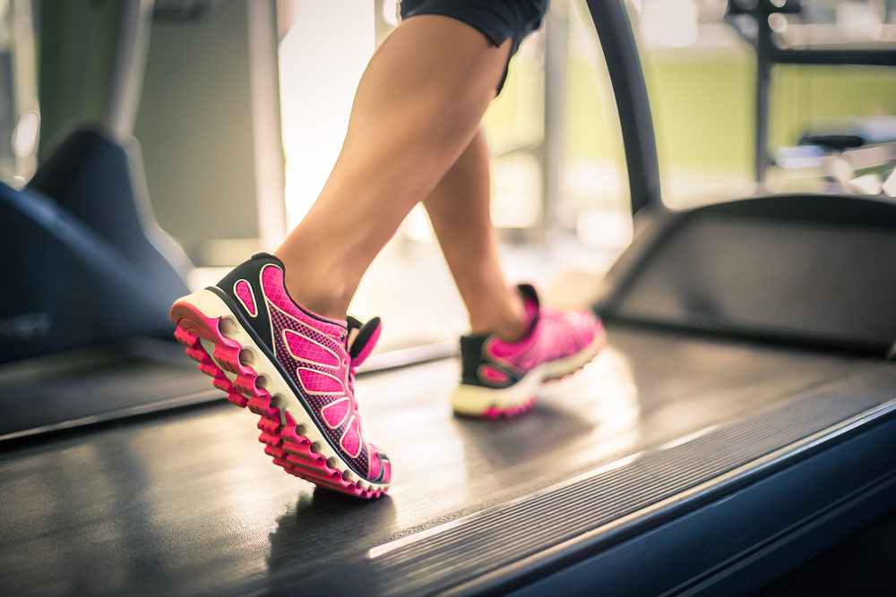 Fitness girl running on treadmill