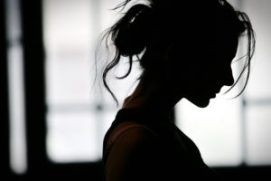 Silhouette of a young woman with her hair tied back